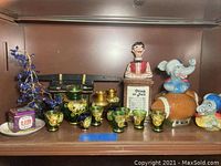 Photo of Japanese glass cups and vessels, vintage sake container, and ceramic music box with bartender figurine.