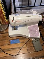 Side view of Singer Futura sewing machine showing foot pedal and cord.