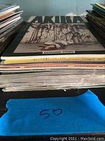 Stack of comic books showing titles including Akira and others in a vertical pile with visible wear.
