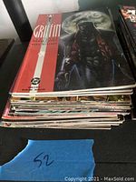 Stack of five comic books with focus on top fee being Griffin series from DC Comics, showing front cover with dark toned artwork and moon background.