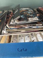 Top bent comics with visible edge wear and creasing in a stack of 13 comics.