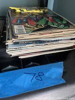 Stack of approximately 21 comic books from various titles, showing different cover art edges and slight bends.