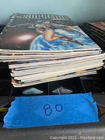 Stack of 23 comic books with visible Supreme covers on top showing colorful illustrations of a character in space.