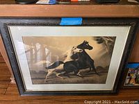 Full view of framed horse art print showing two horses running in storm with mat and frame.