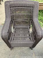 Top view of a single dark brown wicker chair showing detailed woven seat and back.