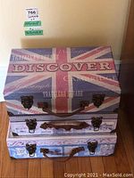 Stack of three small painted suitcases with UK themed top design showing Union Jack and 'Discover' text.