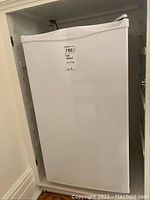 Full view of closed white Diplomat bar fridge positioned in recessed wall space.