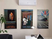Photo showing all three Venice Simplon Orient Express posters hung on a wall beneath an air conditioner unit in a room.
