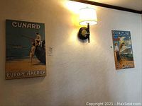 Two mounted vintage travel posters on a wall: Cunard Europe-America on the left, Royal Line Bristol-Canada on the right.