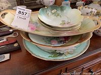 Stacked view of the RS Porcelain dish set showing three small scalloped bowls, oblong serving plate, and round plates underneath.