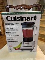 Box front showing Cuisinart PowerBlend 600 7-speed electronic blender with features listed and a fruit smoothie illustration.