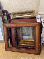 Photo showing the five frames stacked together, ranging from gold ornate to wooden frames with beaded and floral details