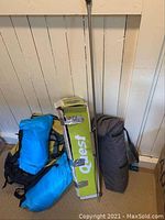 Photo of all items together showing Quest tent box, chairs in bags, and blue backpack with additional gear
