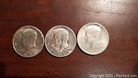 Obverse side of three 1971 Kennedy US half dollar coins showing Kennedy profile.