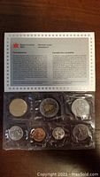 Photo of the 1997 Canadian uncirculated coin set sealed in original plastic packaging, showing front view of eight coins and accompanying insert.