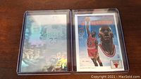 Two Michael Jordan cards in protective sleeves, one hologram and one checklist card, placed side by side.
