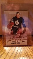 Front of signed Johnny Bower NHL trading card showing autograph and image of Bower in Toronto Maple Leafs goalie uniform.