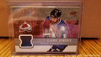 Front of the hockey card showing Peter Forsberg, Colorado Avalanche logo, and embedded blue jersey swatch.