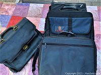 Three laptop bags including a black leather briefcase style bag, a black padded bag with Queen's University patch, and a plain black laptop bag with multiple compartments, arranged on a colored surface.
