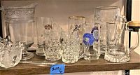 Various vintage glassware including pitchers, mugs, beer steins, and a decorative bowl