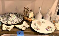 Image showing a variety of hand-painted floral china, butterfly dishes, model ship, and ceramic bells