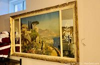 Side angle view of the large framed wall art showing gold ornate frame and etched glass floral panels