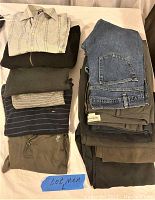 Full view of the stacked men's clothing including shirts and pants.