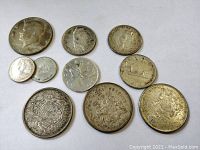 Top view of 11 silver coins showing various Canadian coins and USA 1966 Kennedy half dollar