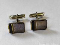 Front view of two rectangular sterling silver cufflinks with a black stripe and visible patina, showing the shape and design detail.