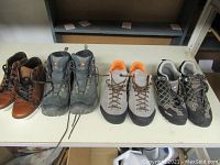 Four pairs of men's shoes on a white table