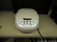 Front view of the white Tiger brand electric rice cooker with control panel and closed lid.