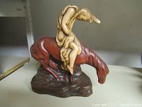 Front view of resin statue showing droopy rider on horse with base.