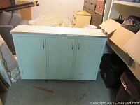 Front view of light blue painted cupboard with three doors and chrome handles.