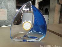 Side view of the 7.5 inch glass ornament with blue and clear glass showing embedded Bulova clock.