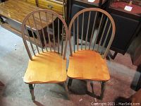 Pair of vintage farmhouse style chairs with natural wood seats and green painted turned legs and stretchers.