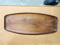 Top view of teak serving tray showing elongated rectangular shape with rounded edges and visible wood grain.