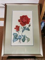 Full view of the framed watercolour painting showing two red roses and leaves on white background.