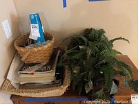 Overview of two baskets, one filled with piano music books and papers, an artificial plant on the table