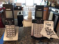 Two VTech cordless phones on charging bases seen on kitchen countertop