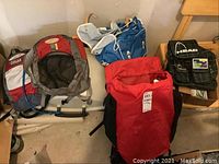 Photo showing all four backpacks arranged on the floor including the external frame backpack and three smaller backpacks.