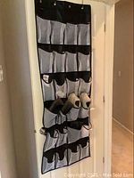 Full view of hanging shoe organizer showing its 12 pocket layout filled with various shoes.