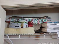 Photo of wrapped items, boxes, and miscellaneous items on a shelf