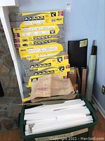 Photo of stacked yellow and gray Subterrain boxes containing HO railroad risers and additional vertical standing tubes and folders.