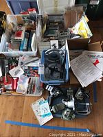 Overview showing large assortment of tools in containers, PanaVise bases and miscellaneous manuals and periodicals