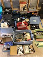 Overhead view of multiple plastic bins containing hardware, tools, grinding wheels and kits