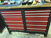 Front view of red metal tool chest with ten drawers and wooden top