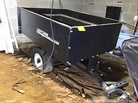 Photo showing the black Craftsman utility wagon from the side with flat tires and trailer hitch in a basement setting.