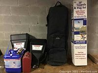 Photo of all seven items: two black Bigbin wall mount dispensers, blue and red plastic containers, black storage bag, and unopened boxed 20-foot flagpole set.