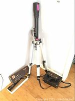 Polaris telescope on tripod with Anscomatic film camera and carrying case on floor.