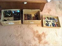 Three cardboard boxes arranged side by side showing overall lot contents